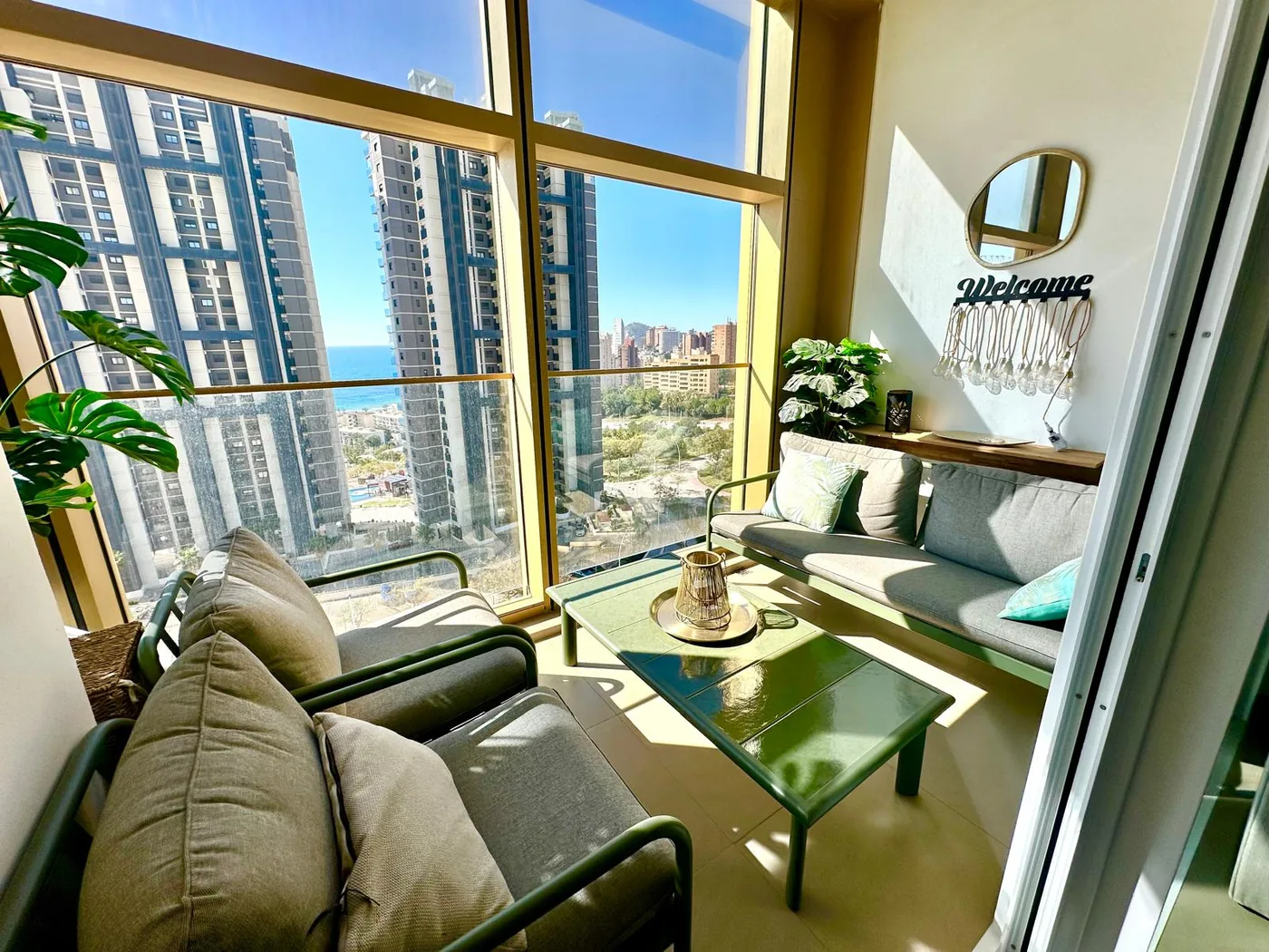El salón de Gold & Gris, con sillones junto al ventanal y vistas a Benidorm y al mar